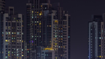 Fototapeta na wymiar Skyscrapers with glowing windows night timelapse.