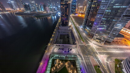 Cityscape of skyscrapers in Dubai Business Bay with water canal aerial night timelapse