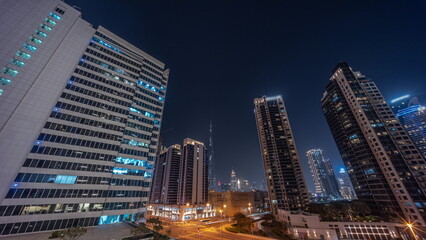 Aerial panoramic view to Dubai downtown and difc skyscrapers night timelapse.