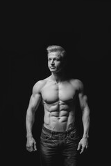 Naklejka na ściany i meble Fitness concept. Muscular and fit torso of young man having perfect abs, bicep and chest. Male hunk with athletic body on black background