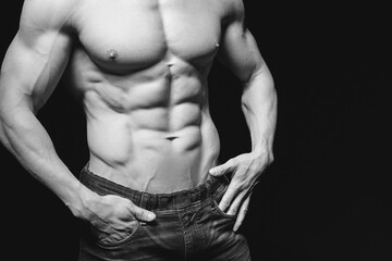 Fototapeta na wymiar Fitness concept. Muscular and fit torso of young man having perfect abs, bicep and chest. Male hunk with athletic body on black background