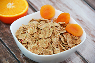 dietary oatmeal muesli and orange dried apricots in a white plate