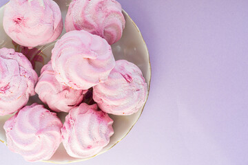 Homemade pink marshmallow - zephyr on a light lilac background
