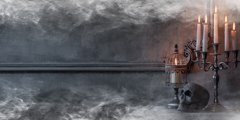 Mystical Halloween still-life background. Skull, candlestick with candles, old fireplace. Horror...
