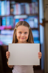 Girl holding a white sheet of paper. Close up