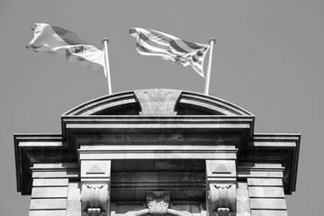 Coexistence - Spanish and Catalonia flag in Barcelona. Black and white vintage photo style.