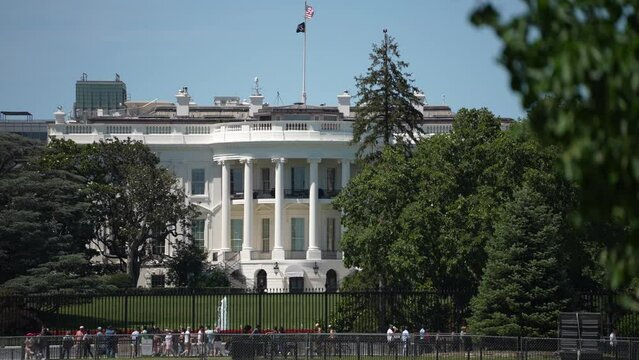 The White House showing the oval office of the president of the United States with tourists looking on a bright summer day.