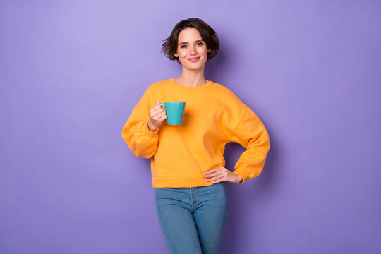 Portrait Of Charming Satisfied Person Hold Coffee Cup Put Hand Waist Isolated On Purple Color Background