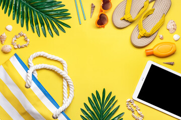 Swimming accessories - trendy beach bag with stripes, black glasses, white tablet, palm leaf, yellow flip flop on yellow background Flat lay Top view Summer, travel, vacation concept - 512349540