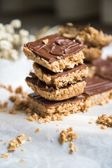 High energy oatmeal squares, made with oatmeal, peanut butter, honey, coconut oil, and cashews, topped with chocolate. Close view and shallow depth of field.
