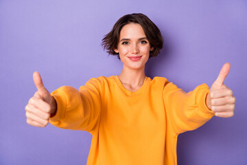 Portrait of cheerful pretty girl arms finger demonstrate thumb up good mood isolated on purple...