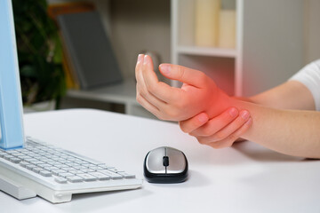 Hands of a person with carpal tunnel syndrome, a computer and a mouse
