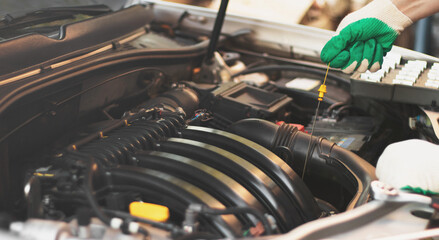 Checking the engine oil level by a mechanic in a car service