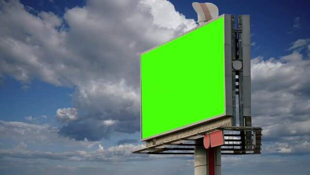Green Screen Outdoor Billboard Cloudy Blue Sky Lapsed. Tall billboard with a green screen standing in front of a lapsed cloudy sky. Steady shot