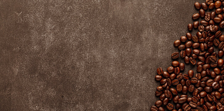 Vintage stone background with roasted coffee beans arranged on right edge