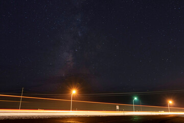 Milky Way stars above a truck streaking past on an interstate highway