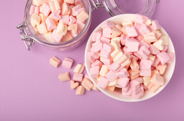 Marshmallow bowls on a lilac background.Closeup strawberry flavored chewy candy.Snacks and snacks for parties.Spice for coffee and cocoa.Winter food concept.Place for text.