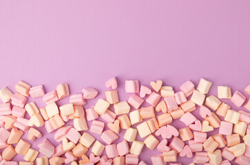 Marshmallow on a lilac background.Closeup strawberry flavored chewy candy.Snacks and snacks for parties.Spice for coffee and cocoa.Winter food concept.Place for text.