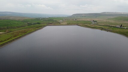 Aerial view of a lake surrounded by rural farmland and green countryside. 