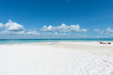 Obraz premium A young mother relaxes on the beach as her young son runs on the beach, Isla Mujeres, Mexico 