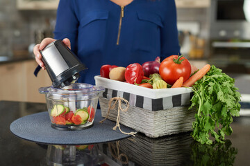 woman using blender with vegetable