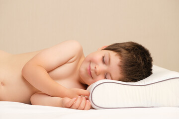 Obraz na płótnie Canvas A 5-year-old boy lies on a children's orthopedic pillow made of memory foam