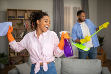 Cheerful African American Spouses Having Fun Cleaning Room At Home