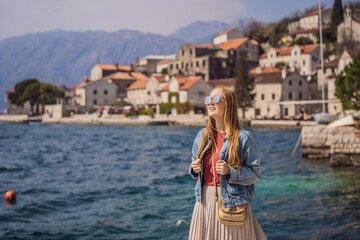 Woman tourist enjoying Colorful street in Old town of Perast on a sunny day, Montenegro. Travel to Montenegro concept. Scenic panorama view of the historic town of Perast at famous Bay of Kotor on a