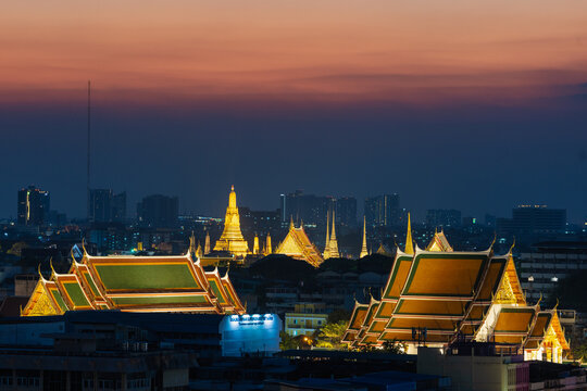 Wat Pho and Wat Arun temples illuminated at dusk in Bangkok, Thailand