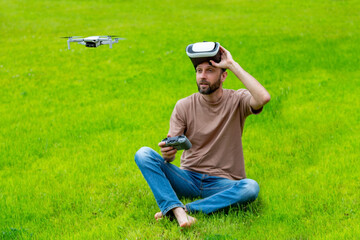 young man with virtual reality vr headset is operating drone with natural background. Technology concept