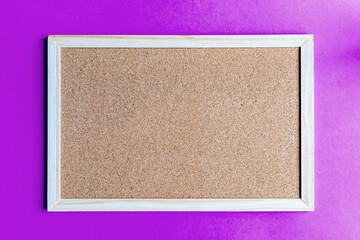 Fototapeta premium A cork board is a framed section of cork backed with wood or plastic. Typically, it is used as a bulletin board, because the resilient nature of cork makes it ideal for sticking pins and tacks into. 