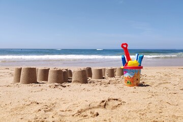 Beach with sand castles and kids toys for summer vacation