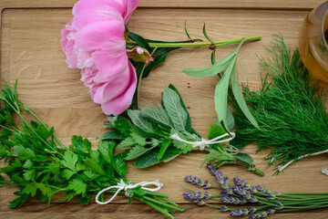 Various herbs picked from the garden, getting ready for drying, on wooden background