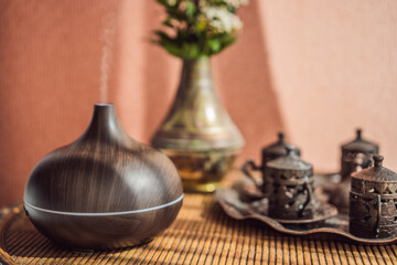 Aroma oil diffuser with aroma oil on table at home. Air freshener