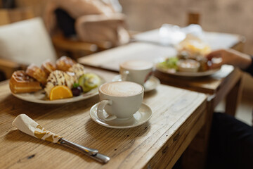 Whole wheat waffles, ice cream, kiwi and coffee on brown wooden rustic table.