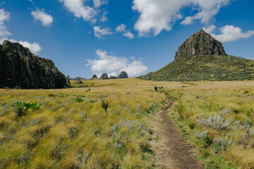 Rear view of a group of hikers against a mountain background at the Dragons Teeth at Ol Doinyo Lestima Mountain in Aberdares, Kenya