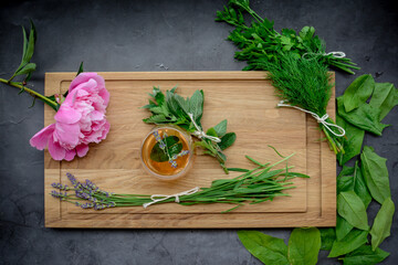 Various herbs picked from the garden, getting ready for drying, on wooden background