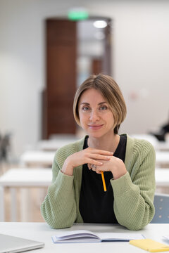 Returning To University As Mature Student. Happy Female Adult Learner Smiling At Camera While Studying In Classroom, Middle-aged Woman Getting Second Higher Education, Attending Educational Courses