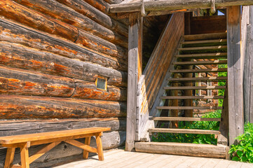 Obraz premium Wooden staircase in an old house. The entrance to the house is made of logs. Stairs to enter a house in the countryside.