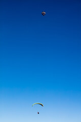 Blue sky gradient with balloon and paraglider.