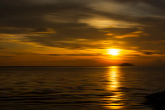 Beautiful sunset background at the beach motion blur. © Jenn Miranda