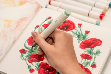 Hand drawing a red poppy wreath sketch in a sketchbook with alcohol based sketch drawing markers. Remembrance Day and Anzac day drawing