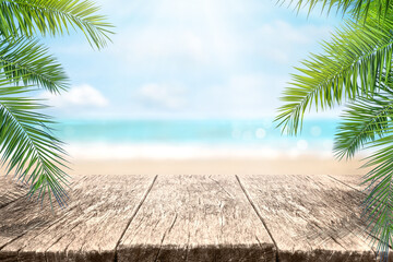 Empty wood table over blue sea, beach and palm leaves background in summer day. Background with...