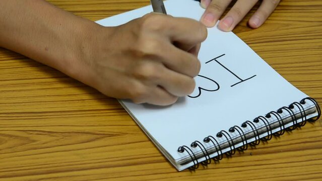 A man writes "ILoveU" with markers