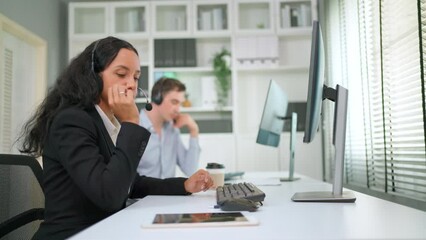 Attractive businesswoman wearing headset looking at computer and make video conference with customer. Pretty girl customer service manager speaking to customer via web cam. Customer service 