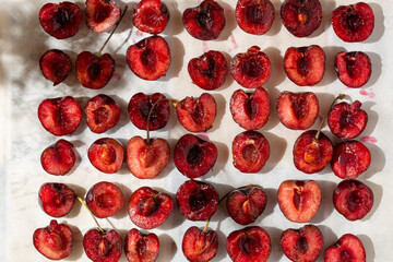 Halves of sweet cherry berries on baking sheet. Roasted Cherries. Ready for baking. Top view.