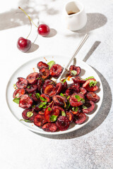 Roasted cherries. Baked sweet cherry berries with balsamic vinegar and herbs. Delicious breakfast idea. Close-up.
