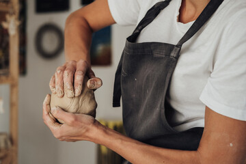 Unrecognisable Female Potter Master Preparing Pile of Clay to Creating Pot on a Pottery Wheel in Her Ceramic Studio
