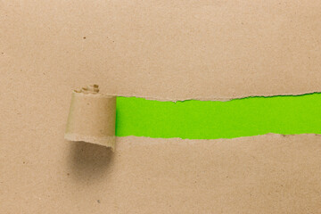 Ripped recycle brown paper with empty space on green background