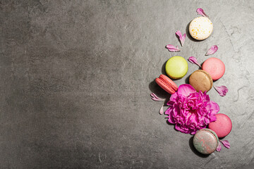 Macarons with peony flower on a stone background. Sweet dessert, colorful and pastel colors